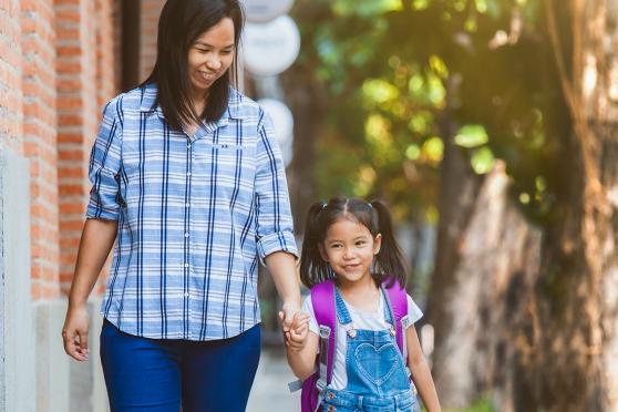 A mother walking her young daughter to school