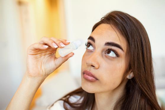 A woman using eye drops