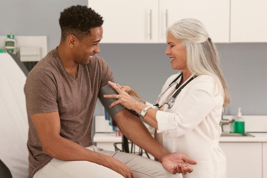 A female doctor giving an adult man a health screening test