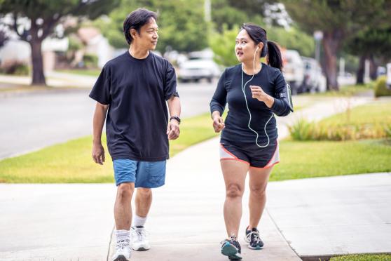 Two people power walking with each other