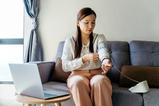 Woman monitoring her blood pressure at home