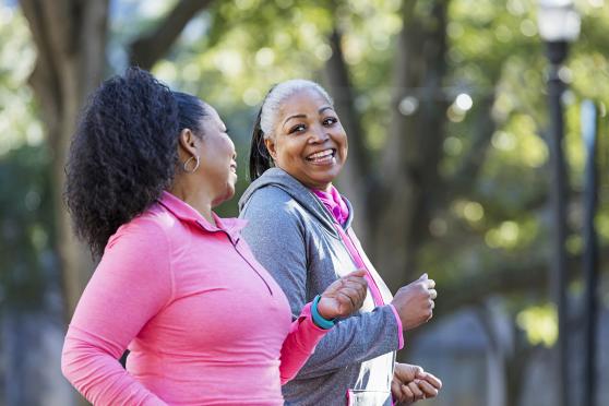 Two women jogging together while chatting