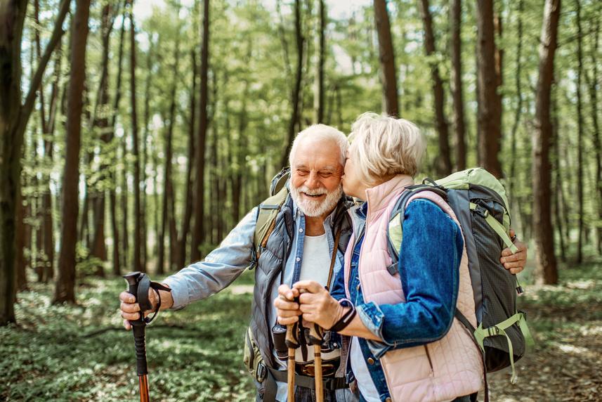 An older couple walking in the woods