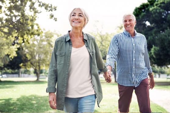 An older couple holding hands and walking together