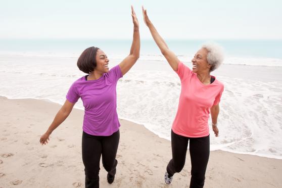 Two women jogging at the beach to help maintain a healthy weight