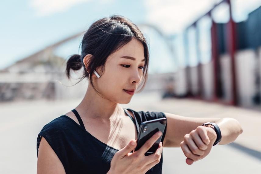 A young woman checking her watch during a jog