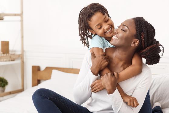 A mother and her daughter hugging and smiling