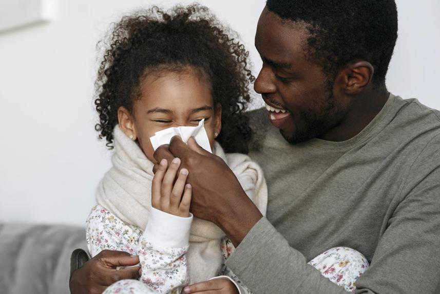 Child with a cold blowing her nose